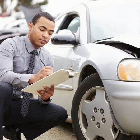 Loss Adjuster Inspecting Car Involved In Accident